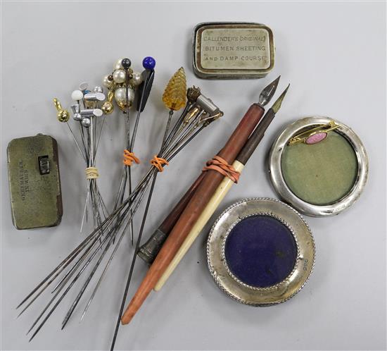 A collection of hatpins and two small silver photo frames